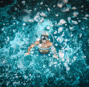 High angle view of shirtless man swimming in sea