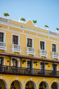 Low angle view of yellow building against sky