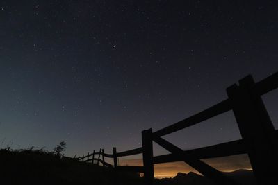 Low angle view of silhouette field against sky at night