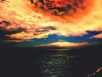 Scenic view of sea against cloudy sky during sunset