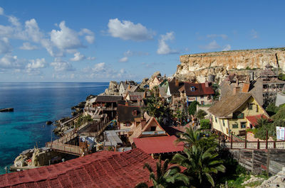 High angle view of townscape by sea against sky