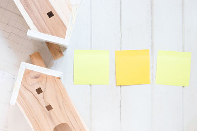 High angle view of yellow paper on wooden table