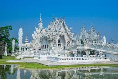 View of temple by building against sky