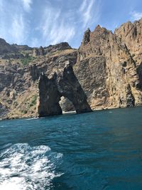 Rock formations by sea against sky