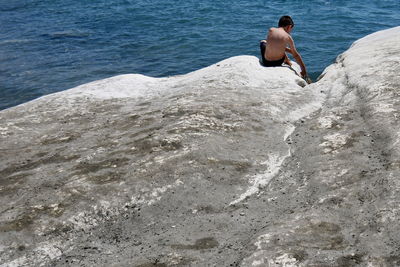 Rear view of shirtless man on beach