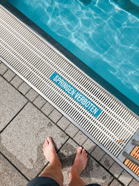 Low section of person standing in swimming pool
