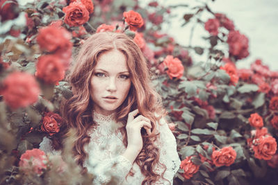 Portrait of young woman with red flowers