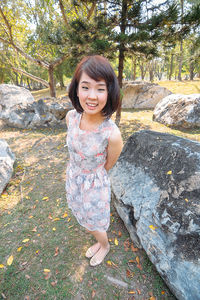 Portrait of young woman standing on rock