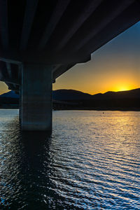 Scenic view of bridge over sea against sky during sunset
