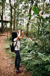 Woman standing on tree trunk