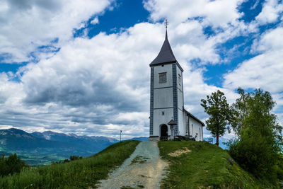 Church on landscape against clouds
