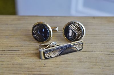 High angle view of cuff links on wooden table