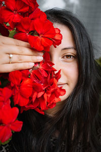 Close-up of woman holding red flower