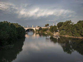 Arch bridge over river against sky