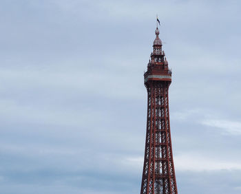 Low angle view of flag on top of tower against sky