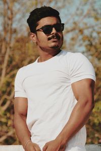 Young man wearing sunglasses standing outdoors
