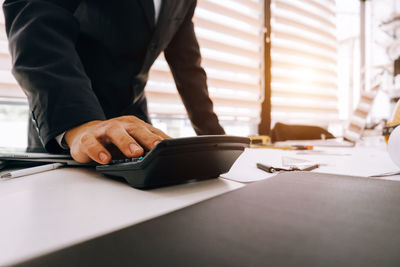 Midsection of man working on table