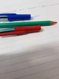 Close-up of pens with pencil on book