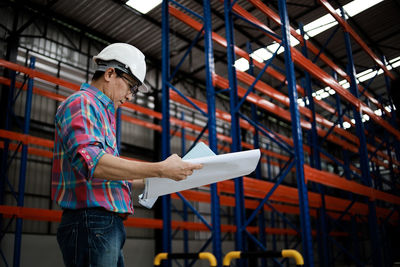 Man working while standing in warehouse