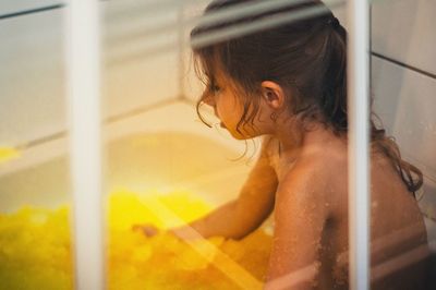 High angle view of shirtless girl in bathroom at home