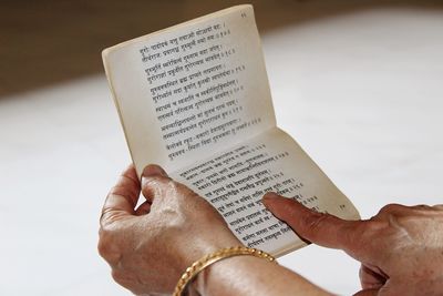Cropped hands of woman reading book