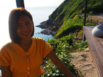 Portrait of smiling young woman by sea