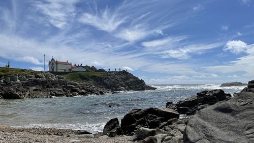 Scenic view of sea by buildings against sky