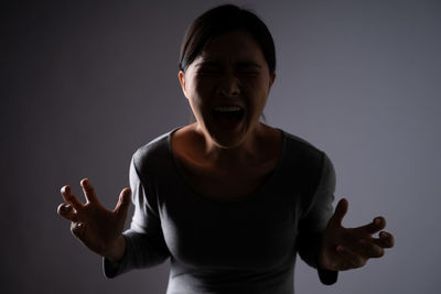 Mid adult man standing against gray background