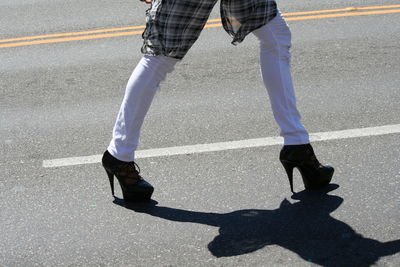 Low section of man walking on road