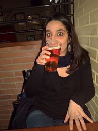 Portrait of a young woman drinking glass