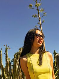 Portrait of smiling young woman against clear sky