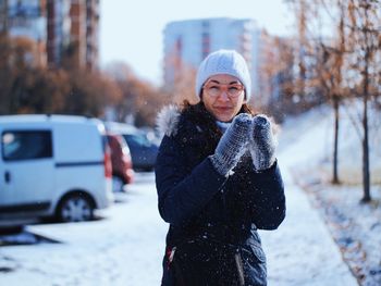 Portrait of young woman standing in snow