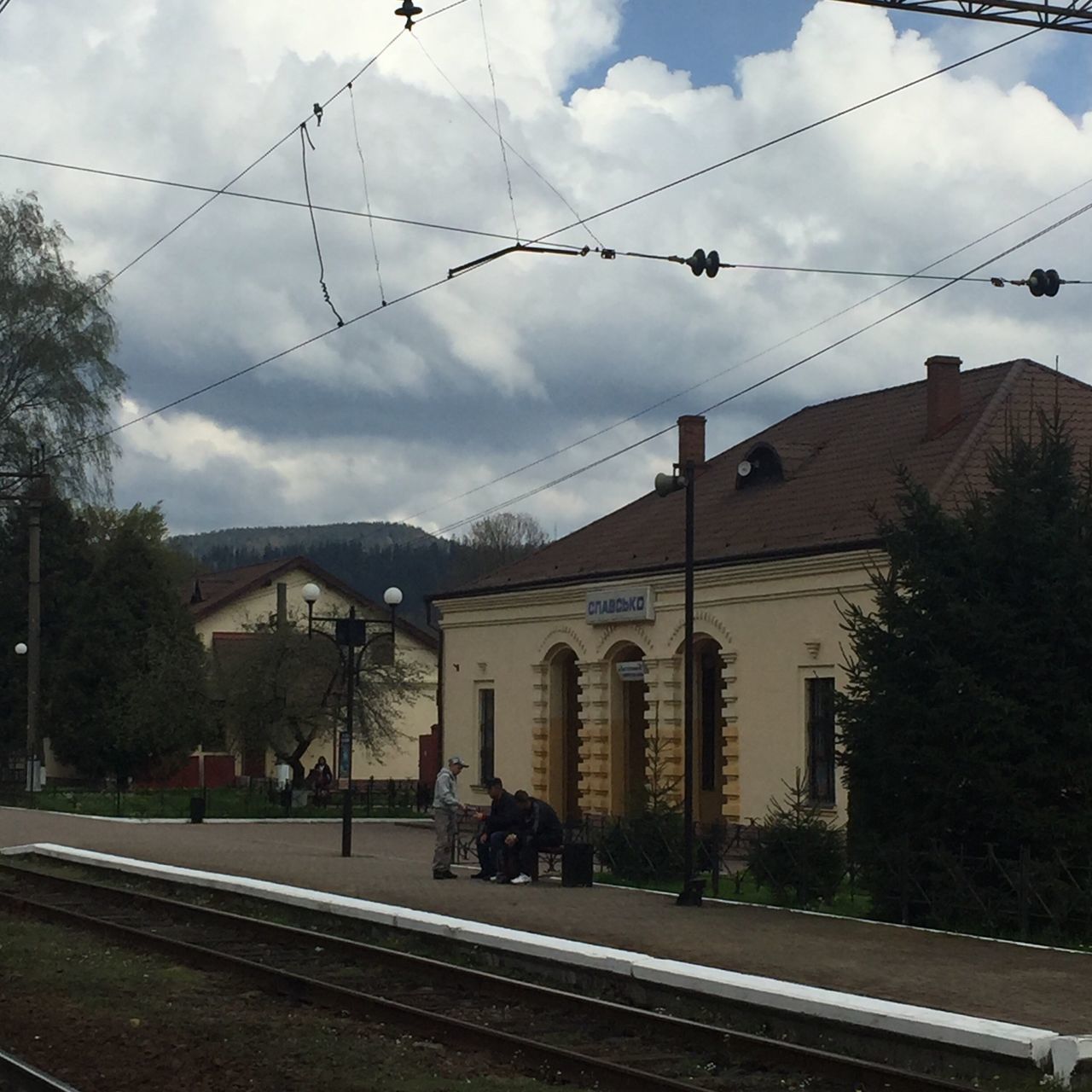 architecture, built structure, building exterior, sky, cloud - sky, power line, cloud, tree, connection, cloudy, cable, railroad track, house, residential structure, residential building, city, railing, rail transportation, bridge - man made structure, roof