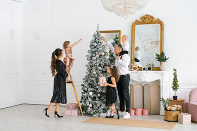 A young family with three children is preparing to celebrate christmas and new year