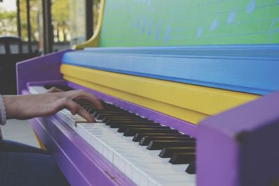 Cropped image of hand playing piano at home