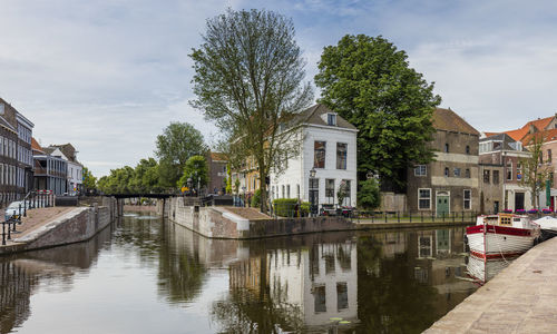 River amidst buildings in city against sky