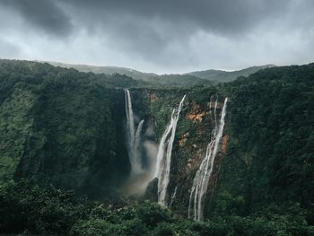 Scenic view of waterfall against sky