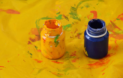 High angle view of yellow and blue paint bottles