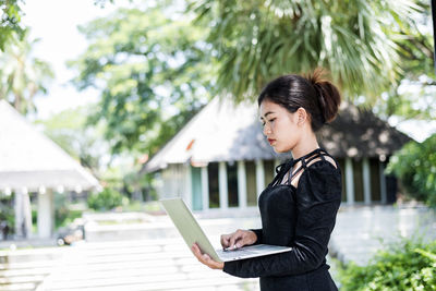 Beautiful businesswoman in black working on laptop . comfortable work or remote work concept.