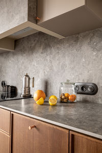 Kitchen counter with jar of oranges and lemons on wood countertop