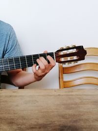 Midsection of man playing guitar