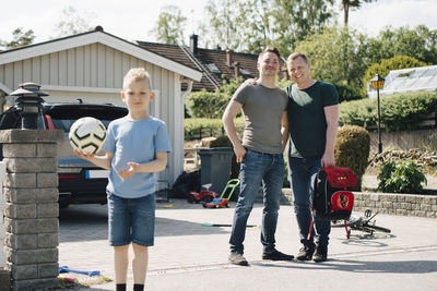 Full length of father and son standing against built structure