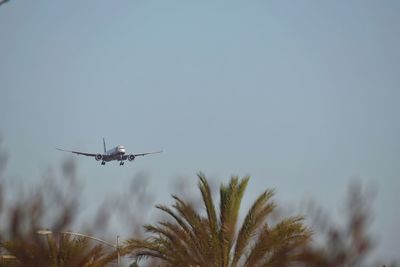 Low angle view of airplane flying against clear sky