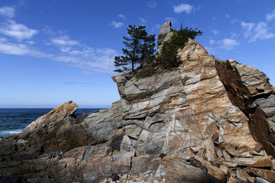 Rock formations in sea against sky