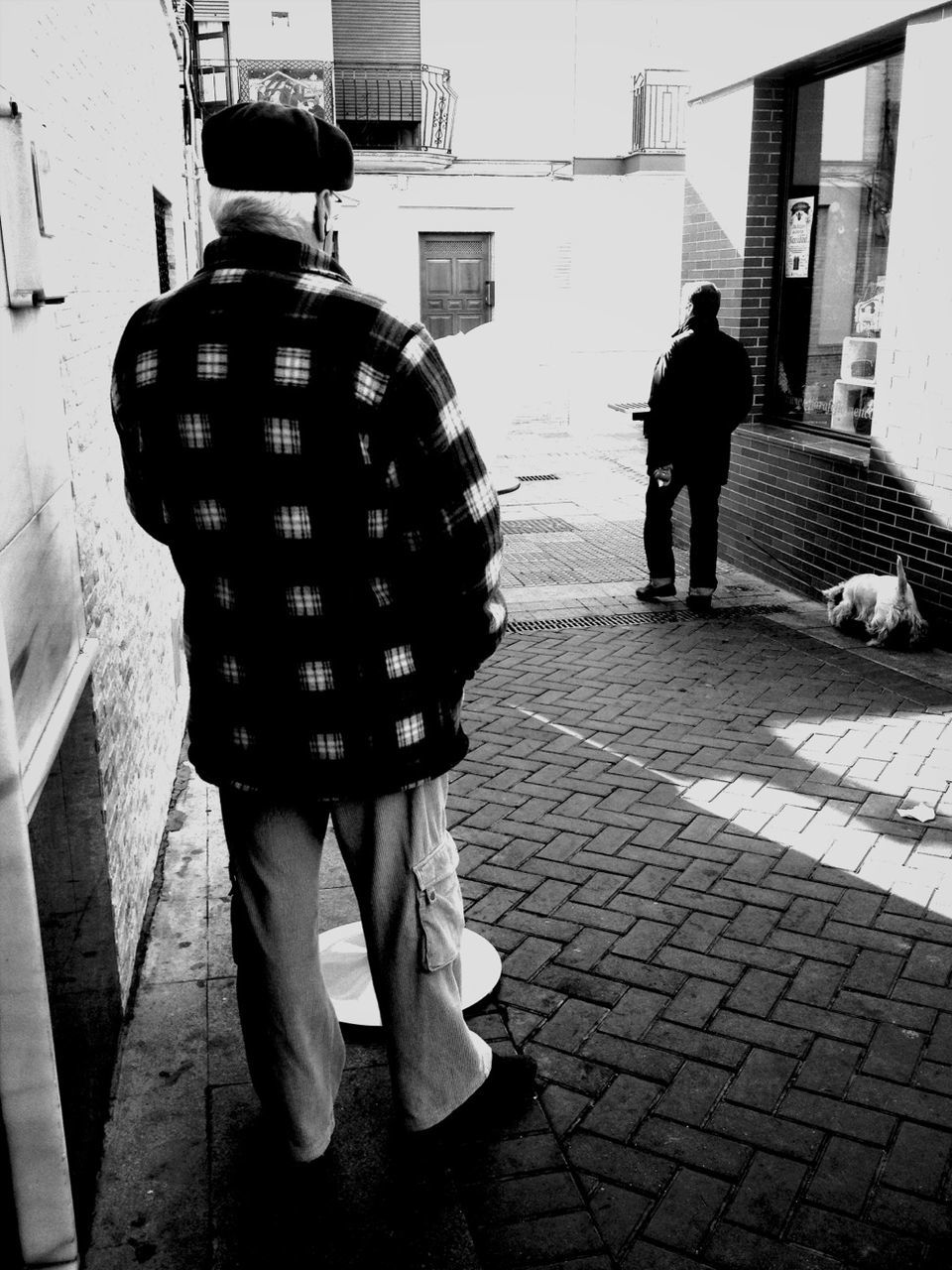 building exterior, walking, full length, rear view, street, architecture, lifestyles, men, built structure, city, person, city life, leisure activity, cobblestone, sidewalk, togetherness, shadow