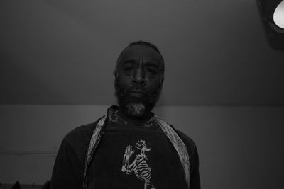 Portrait of man standing against wall