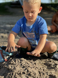 Portrait of boy playing with sand at beach