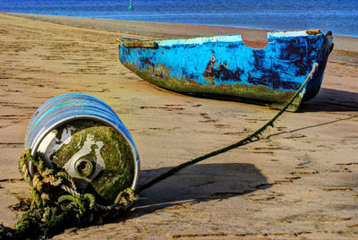 Abandoned boat moored on beach