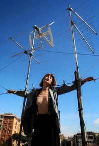 Low angle view of woman standing against sky