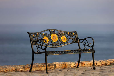 Empty bench against sky